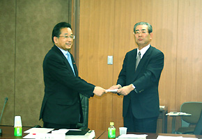 関 金融審議会公認会計士制度部会長より部会報告を受け取る山本大臣(12月22日)